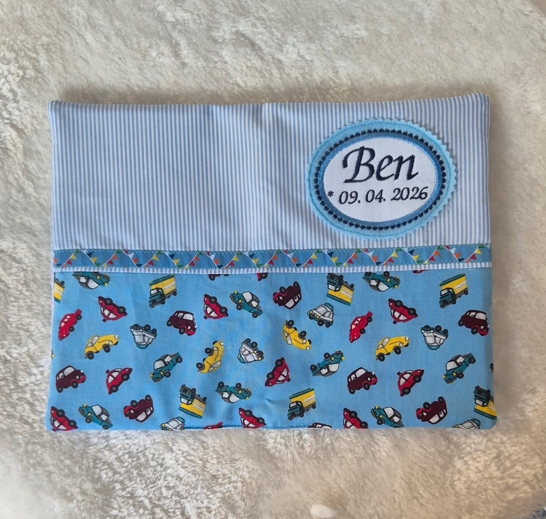 Geöffnete U-Heft-Hülle für Baby Ben mit Käfer-Motiv Stoff und Wimpelband, handgefertigt im Vintage-Stil